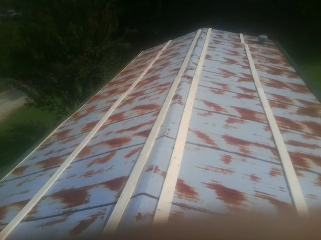 Rusted metal roof panels with new wood purlins before replacement — Storm Damage Roof Repair in Livingston by Roofing Brothers