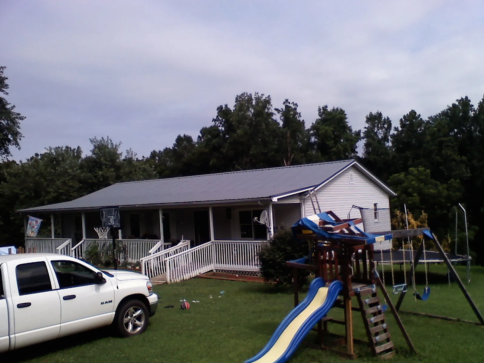 Dark metal roof on a country home with a full length front porch in Livingston